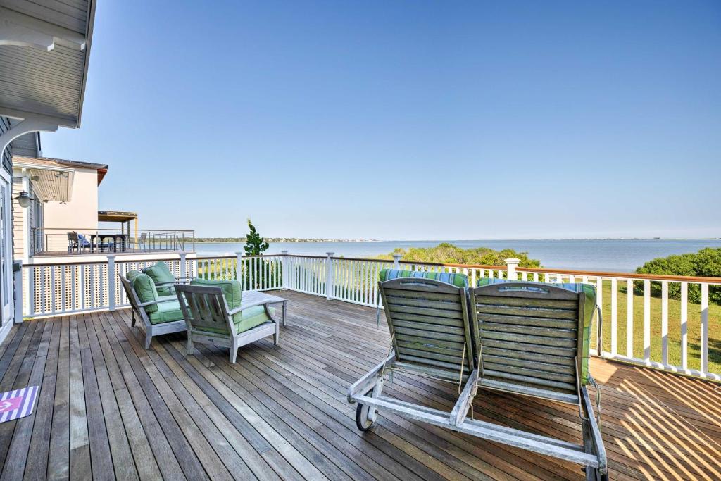 two chairs sitting on a deck overlooking the ocean at Luxe Waterfront East Quogue Home with Beach On-Site! in East Quogue