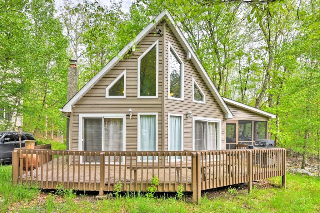 una pequeña casa con una valla de madera delante de ella en Bushkill Mountain Getaway with Community Amenities, en Sandyville