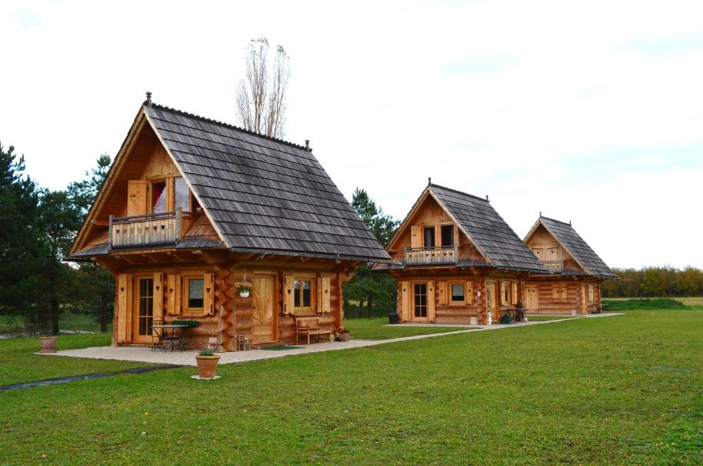 un par de casas de troncos en un campo en La Clé Des Champs en Biltzheim