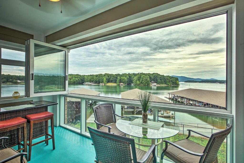balcón con mesa, sillas y vistas al agua en Huddleston Condo Rental on Smith Mountain Lake!, en Huddleston