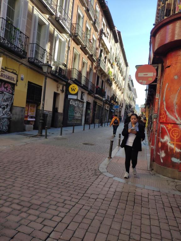 Una mujer caminando por una calle en una ciudad en Cozy Apartment Malasaña FREE Parking, en Madrid