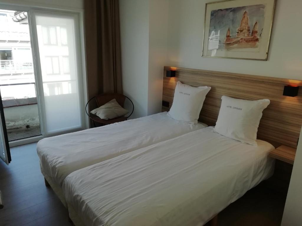 a bedroom with a bed with white sheets and a window at LEHOUCK kamers ontbijt in Koksijde