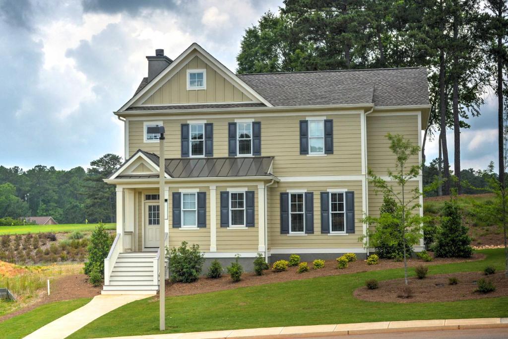 une maison jaune avec un toit gris dans l'établissement Spacious Family-Friendly Retreat with Winter Rates!, à Greensboro