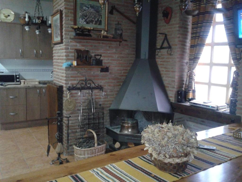 a kitchen with a brick fireplace with a stove at Casa Angelita in Catí