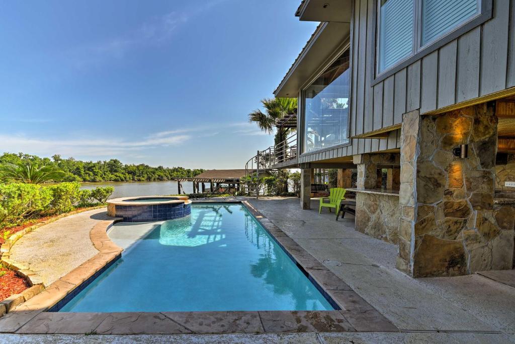 a swimming pool in front of a house at Luxury Home with Pool on San Jacinto Riverfront! in Houston