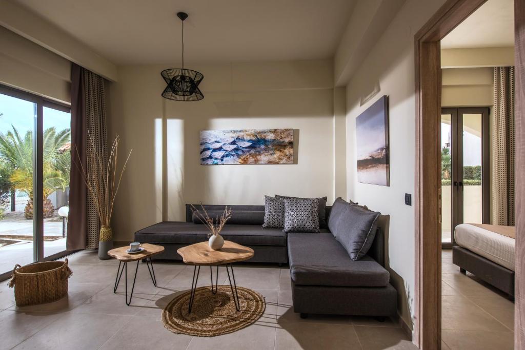 a living room with a couch and a table at Malena Hotel & Suites - Adults Only by Omilos Hotels in Amoudara Herakliou