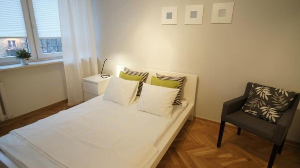 - une petite chambre avec un lit blanc et une chaise dans l'établissement Bagno City Centre 16, à Varsovie