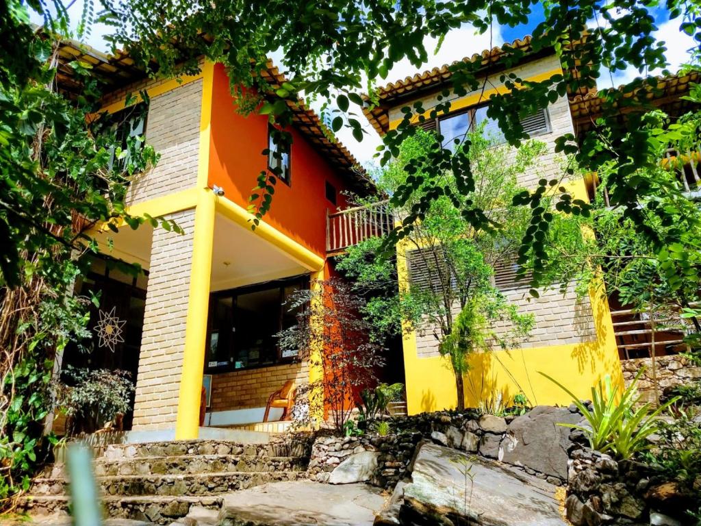 uma casa com um laranja e amarelo em Pousada Alto do Cajueiro em Lençóis