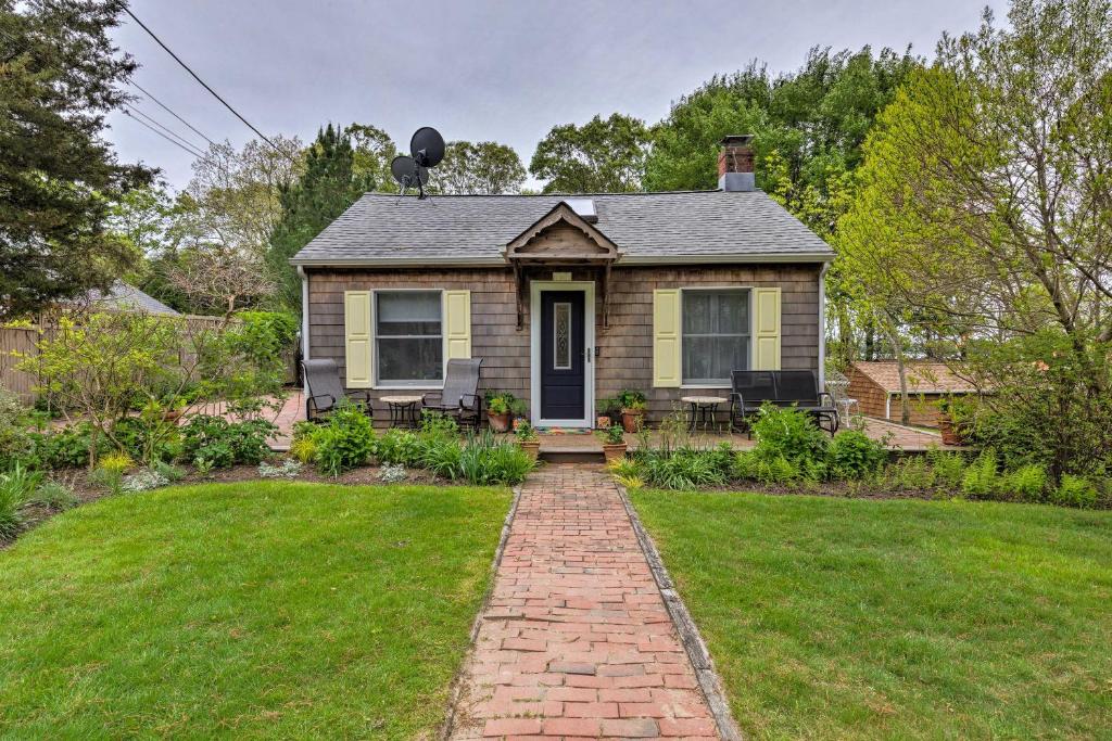 a small house with a brick pathway leading to a yard at Cute East Hampton Cottage with Patio - Walk to Beach in East Hampton