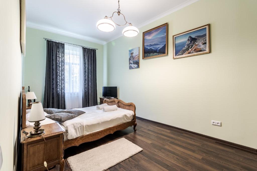 een slaapkamer met een bed en een raam bij Modern Chaikovskogo Apartment in Lviv