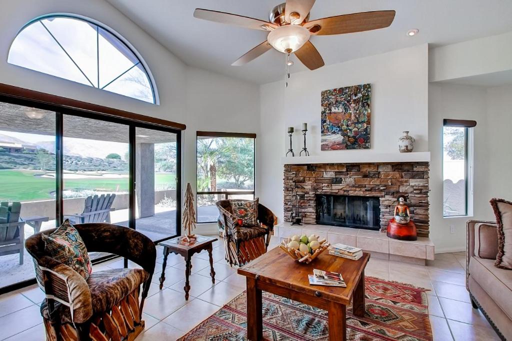 salon z wentylatorem sufitowym i kominkiem w obiekcie Country Club Home 2 BR, 2 BA and Den about 1 Mi to Golf w mieście Borrego Springs