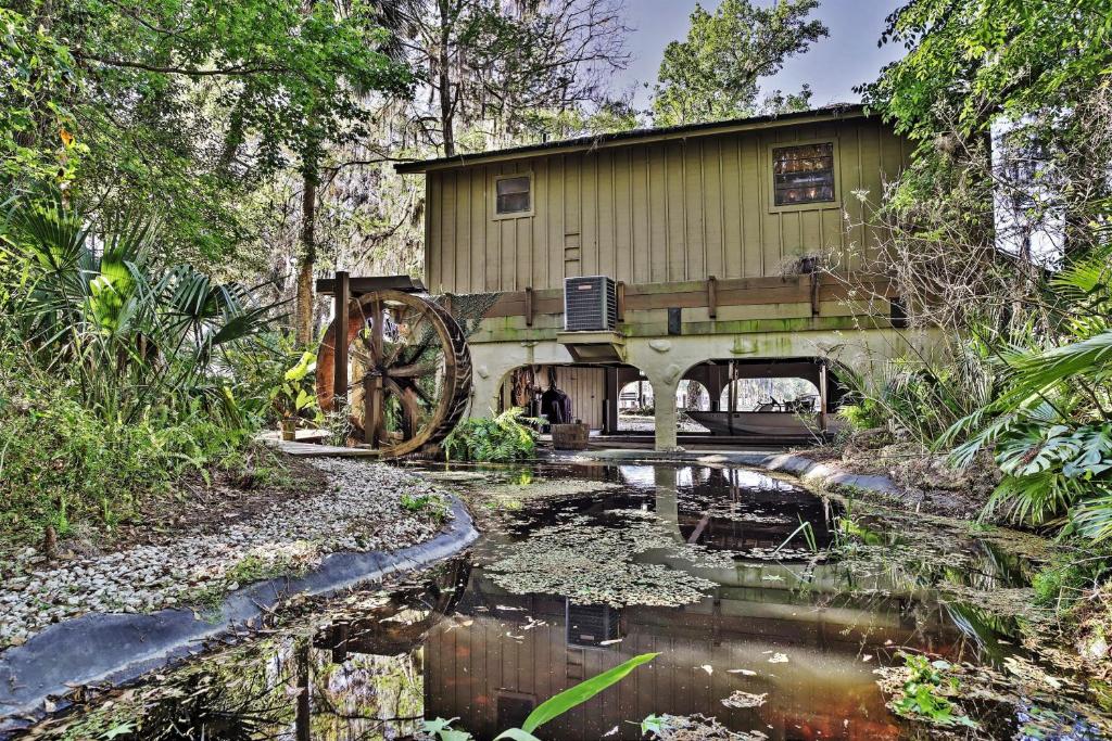 a house with a mill in the middle of a pond at Waterfront Astor Studio Cabin with Private Boat Dock in Astor