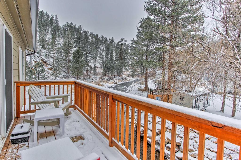 a balcony with two chairs and snow covered trees at Drake Home on Big Thompson River - 3 Mi to Estes! in Estes Park