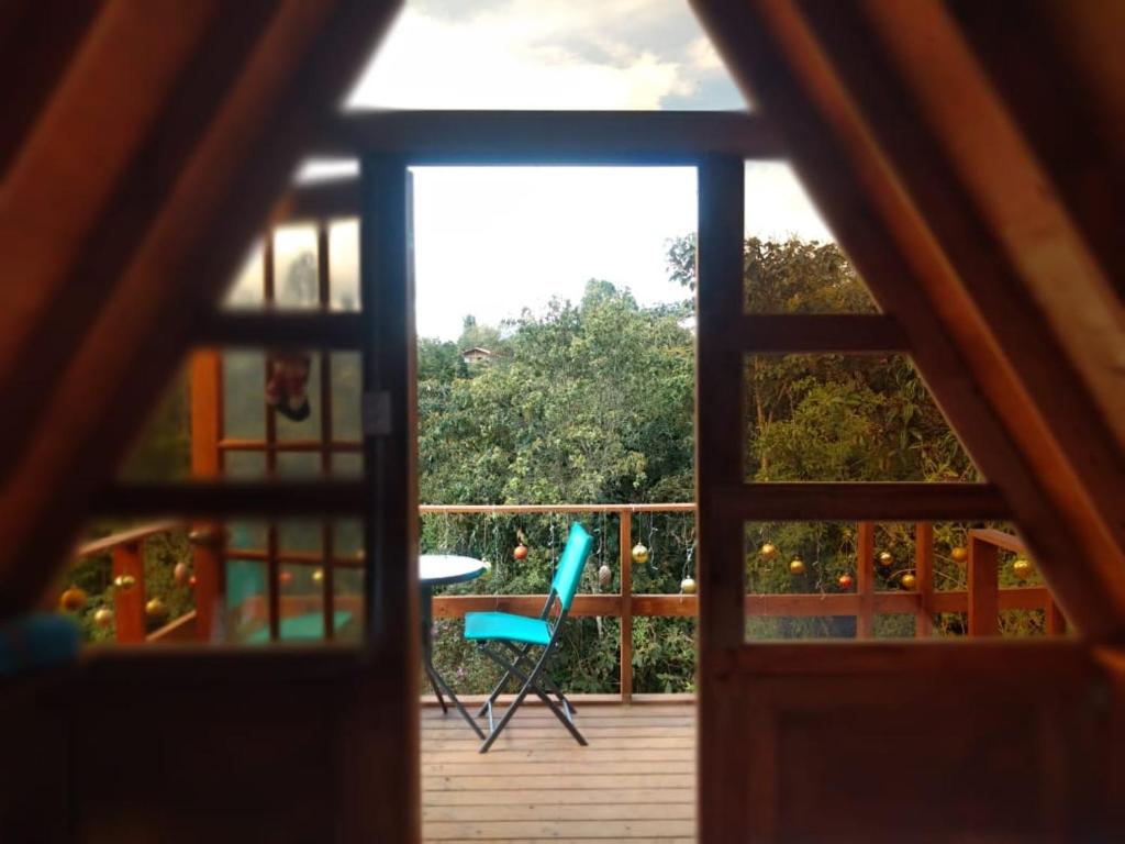 a view of a balcony with a table and a chair at Chalets en Santa Elena en medio del Bosque in Medellín