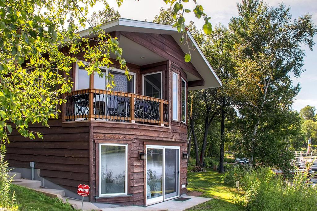 a house with a balcony and a stop sign at Lakefront Brainerd Cabin - Great Rice Lake Fishing in Brainerd