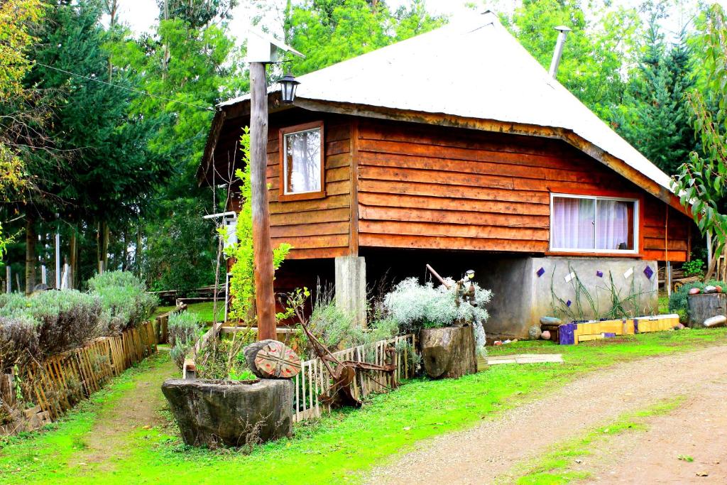 una casa de madera con una valla delante en Cabañas Huilipan Gonzalez, en Nueva Imperial
