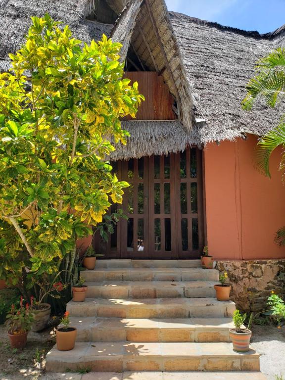 ein Haus mit einer Treppe, die zur Eingangstür führt in der Unterkunft Pousada Aldeia Banzaê in Imbassai