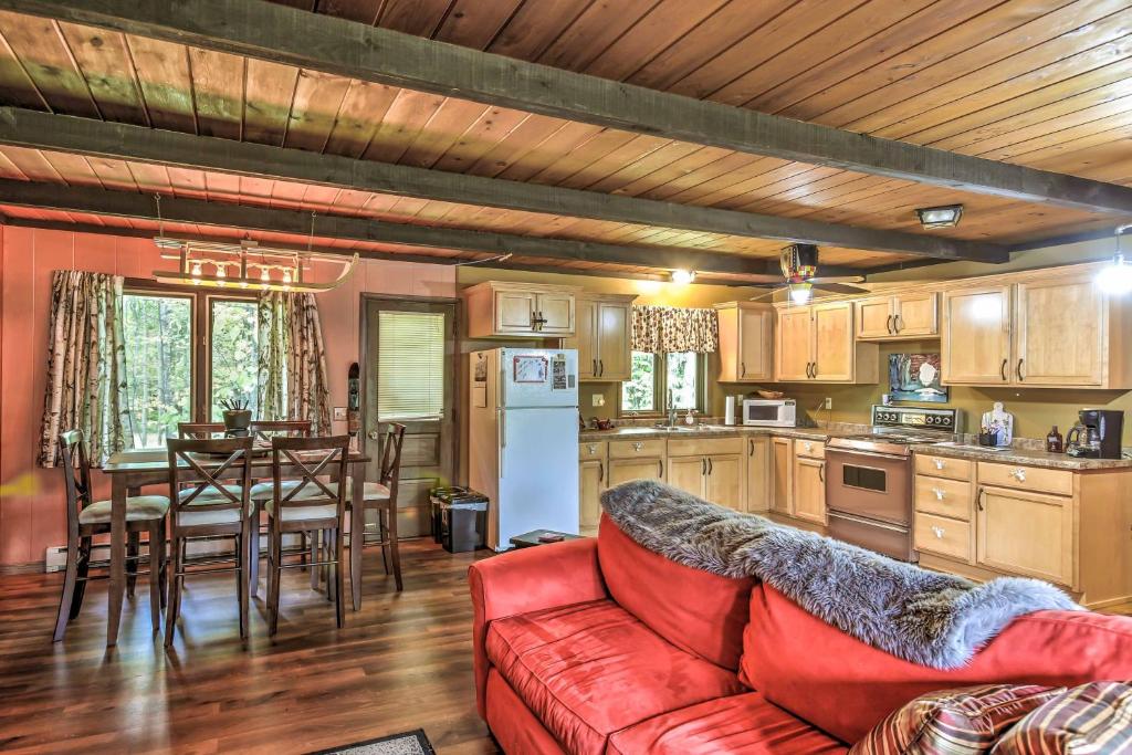 a living room with a red couch and a kitchen at The Lodge at Valhalla at Powderhorn Ski Resort! in Bessemer