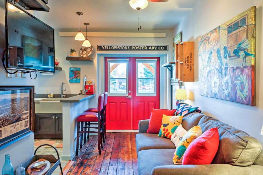 een woonkamer met een bank en een rode deur bij Walkable Studio Apartment in Downtown Livingston! in Livingston