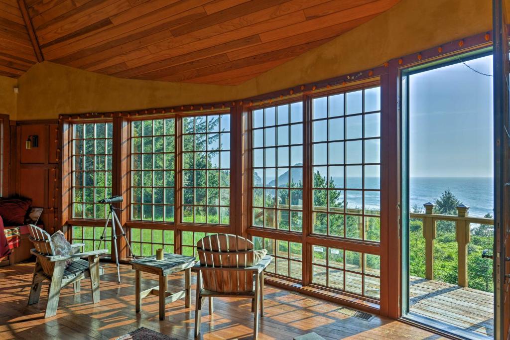sala de estar con mesa, sillas y ventanas en Forested Gold Beach House with Panoramic Ocean Views!, en Ophir