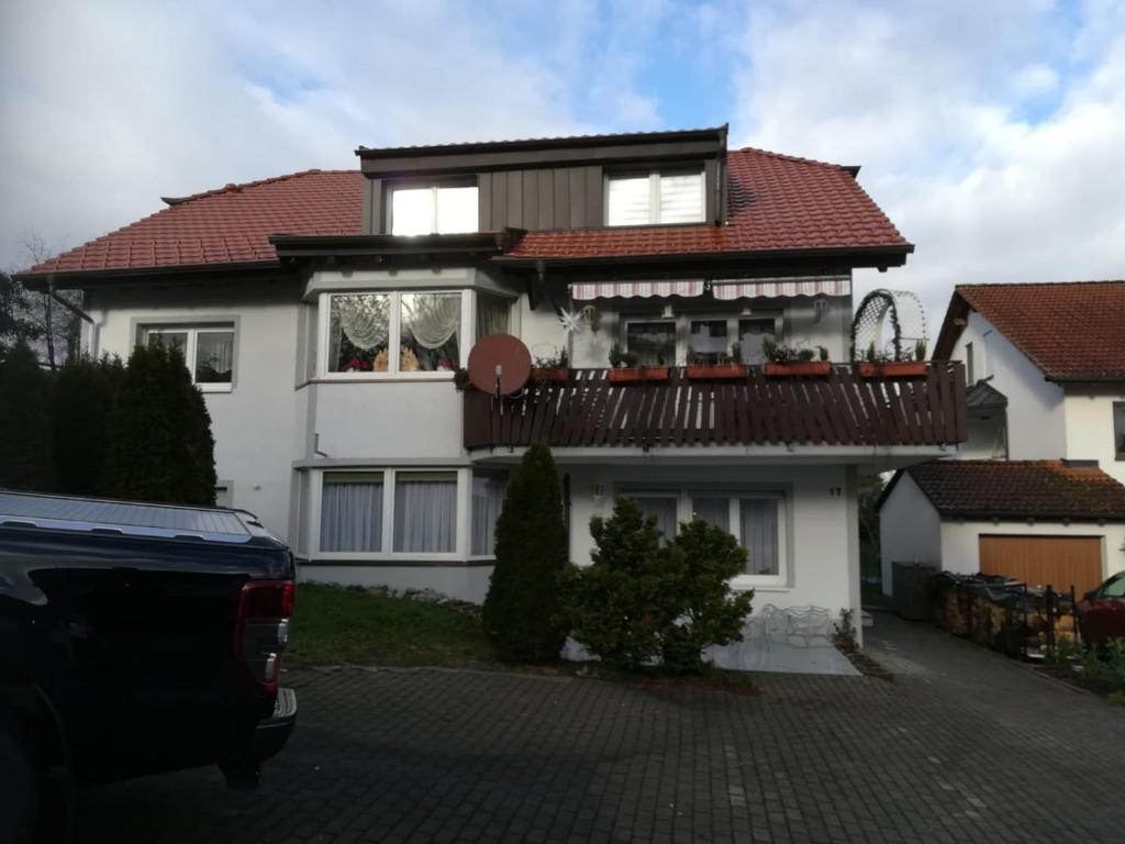 a white house with a balcony on top of it at Diti Apartment in Lottstetten