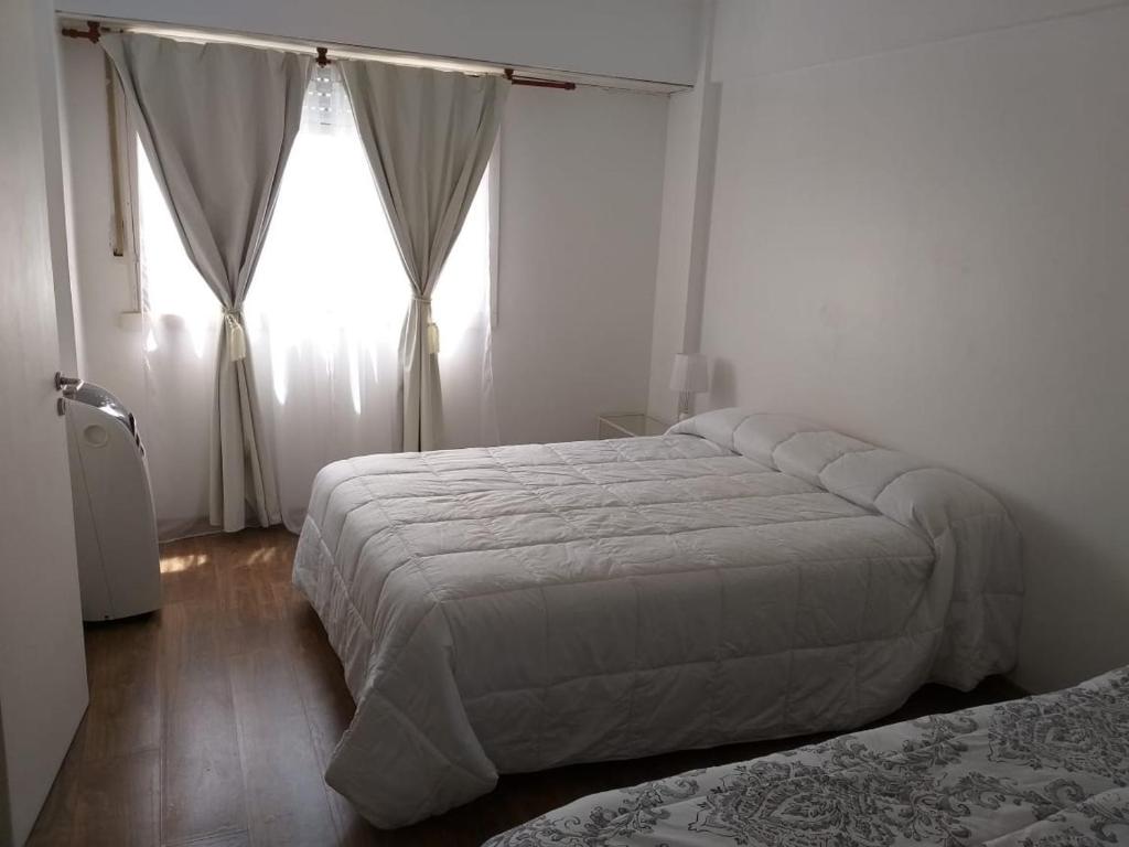 1 dormitorio con 2 camas y ventana en Depto Centro MDP con Cochera, Wifi y Cable en Mar del Plata