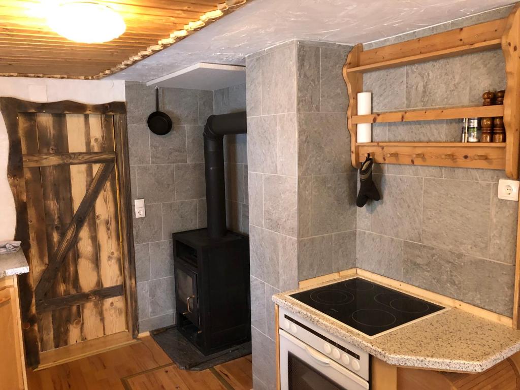 a kitchen with a stove top oven next to a door at Einser Hütte GesbR - Selbstversorgerhaus für 7 Personen in Vordernberg