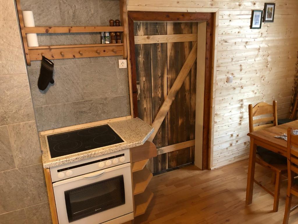 a kitchen with a stove top oven next to a table at Einser Hütte GesbR - Selbstversorgerhaus für 7 Personen in Vordernberg