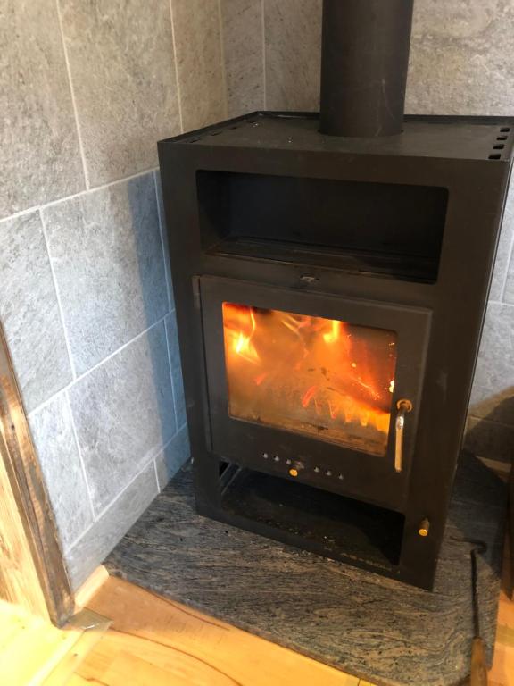 a black wood stove with a fire in it at Einser Hütte GesbR - Selbstversorgerhaus für 7 Personen in Vordernberg