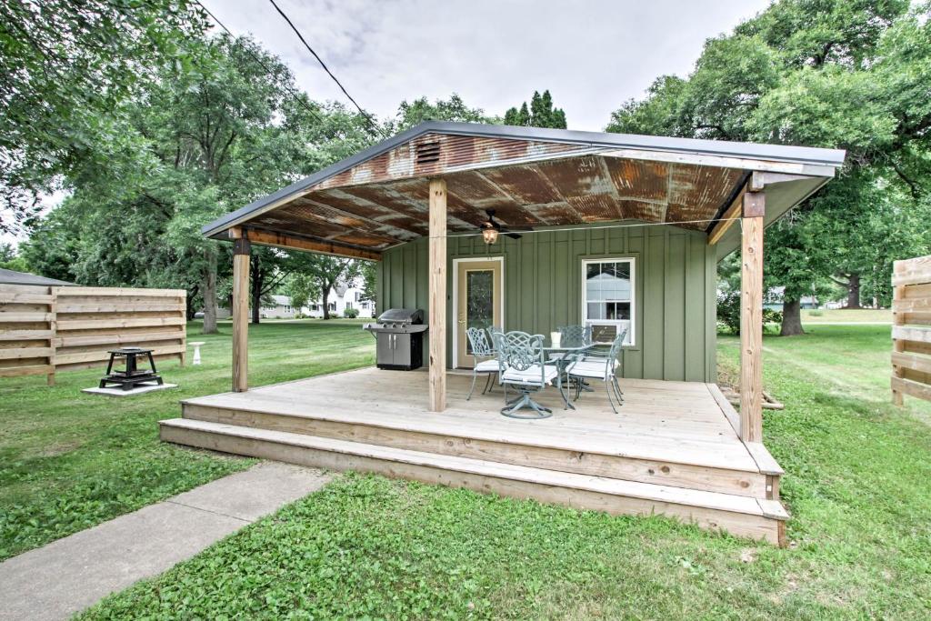 a green cabin with a table and a grill at Lake Pepin Cottage with Patio - Walk to the Marina! in Pepin