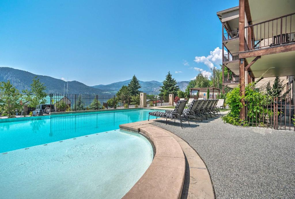 - une piscine en face d'un bâtiment avec des chaises dans l'établissement Cozy Manson Condo on Lake Chelan with Pool Access!, à Manson