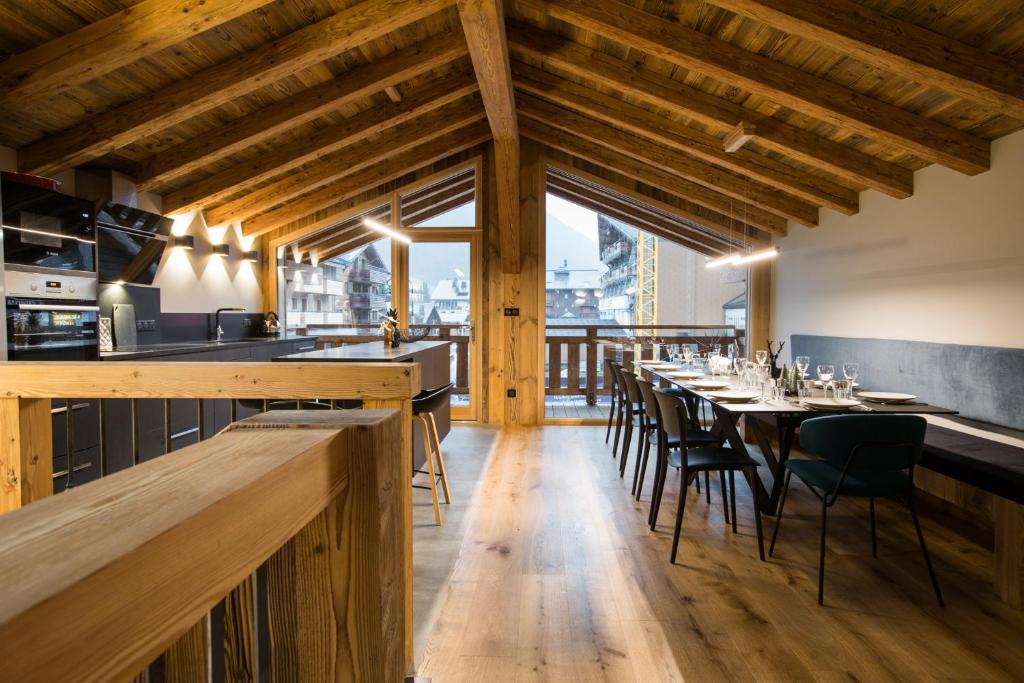 um restaurante com tectos e mesas e cadeiras de madeira em Le Chalet Nativ em Morzine