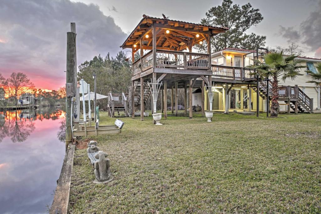 a large house with a deck next to a body of water at Bay St Louis House with Boat Dock and Launch! in Shoreline Park