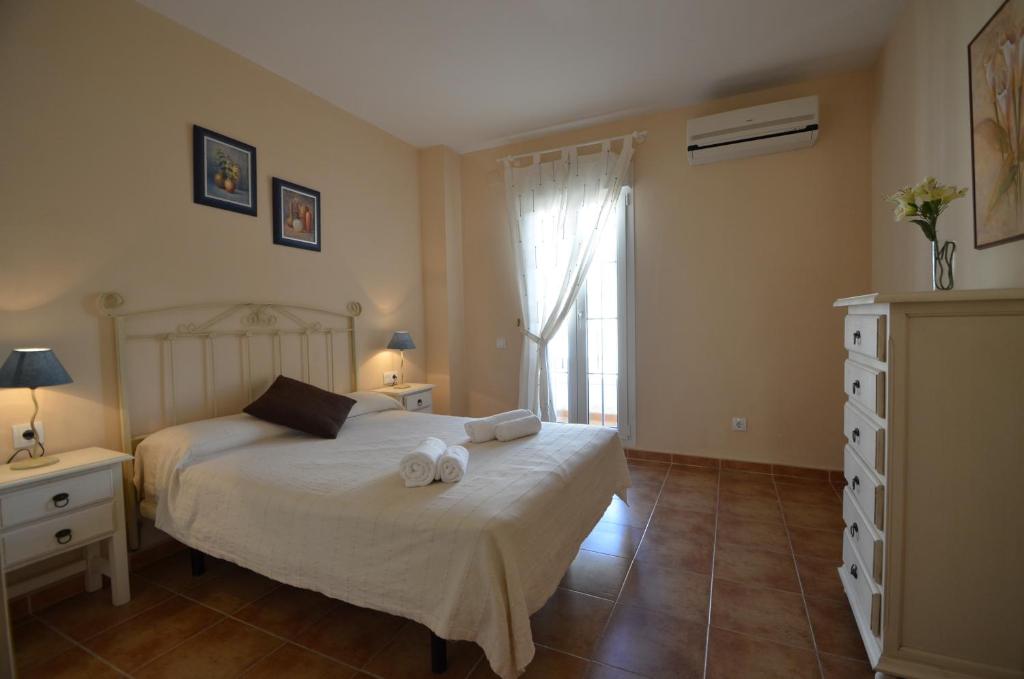 a bedroom with a bed with towels on it at Apartamentos Solmares in Isla Canela