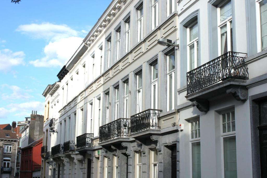 un grande edificio bianco con balconi su strada di B&B Home & the City a Bruxelles