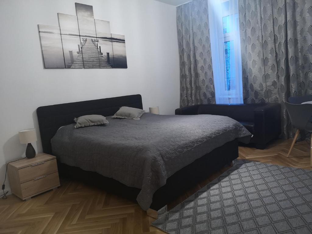 um quarto com uma cama, uma cadeira e uma janela em Angelika Apartments em Viena