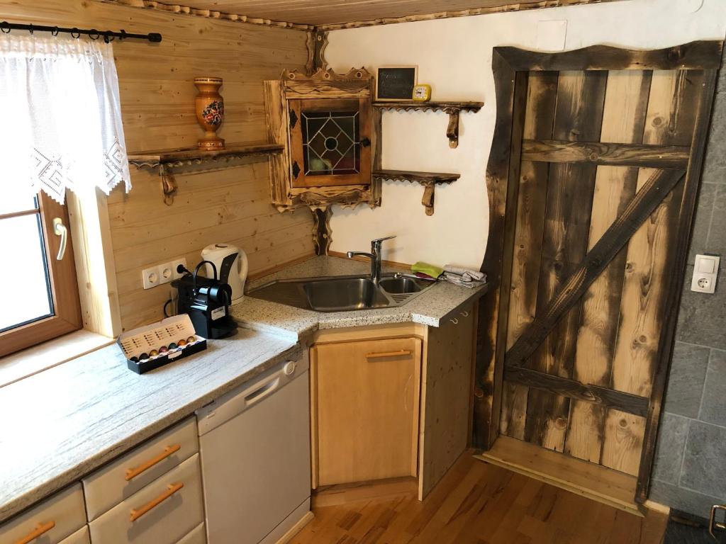 a kitchen with a sink and a wooden door at Einser Hütte GesbR - Selbstversorgerhaus für 7 Personen in Vordernberg