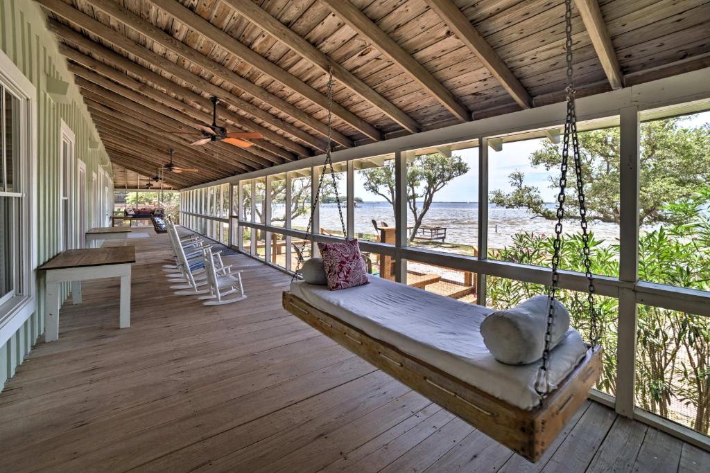 a porch with a swing on a house at Waterfront Perdido Beach House with Canoes and Kayaks! in Perdido Beach