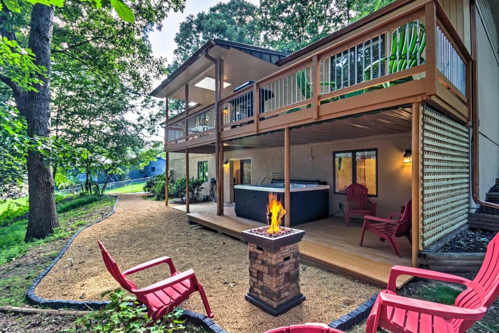 a house with a fireplace in the backyard with red chairs at Arden Vacation Rental with Private Hot Tub and Grill! in Arden