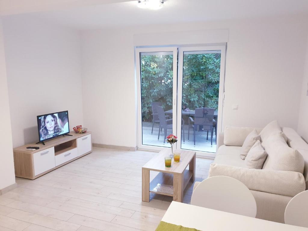 Televízia a/alebo spoločenská miestnosť v ubytovaní Apartments Ellie