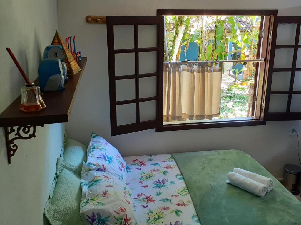 Cette chambre comprend un lit avec une fenêtre et un oreiller. dans l'établissement Casa inteira Ilha Grande, à Abraão