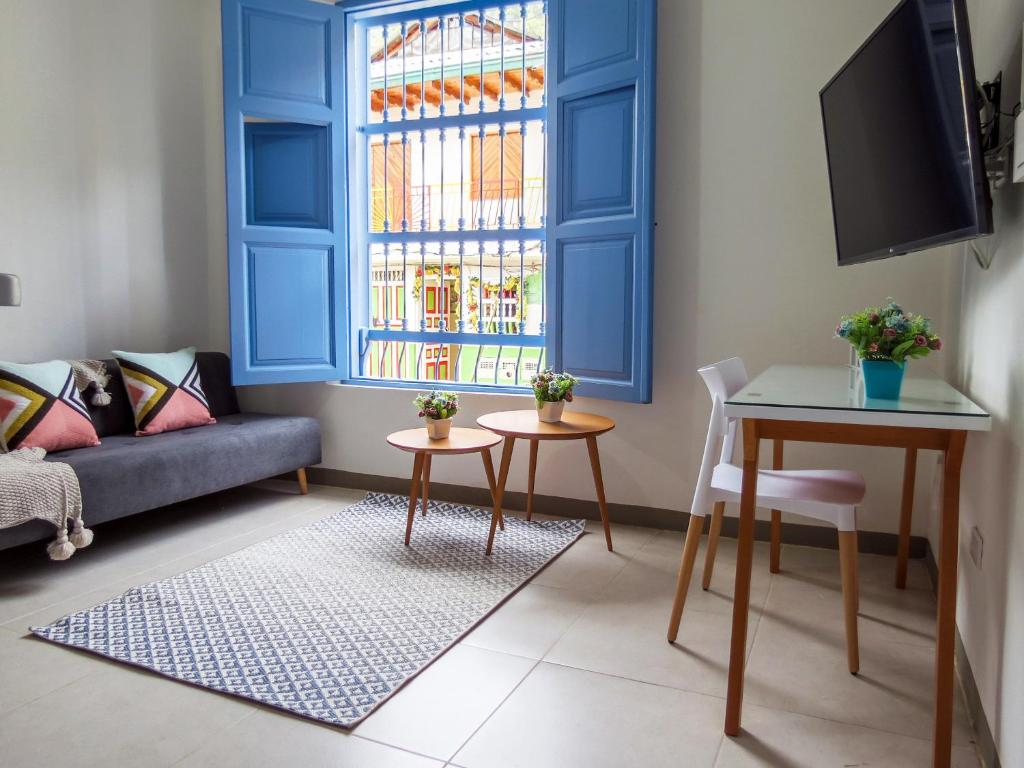 ein Wohnzimmer mit einem blauen Fenster und einem Sofa in der Unterkunft Azulado Jericó in Jericó