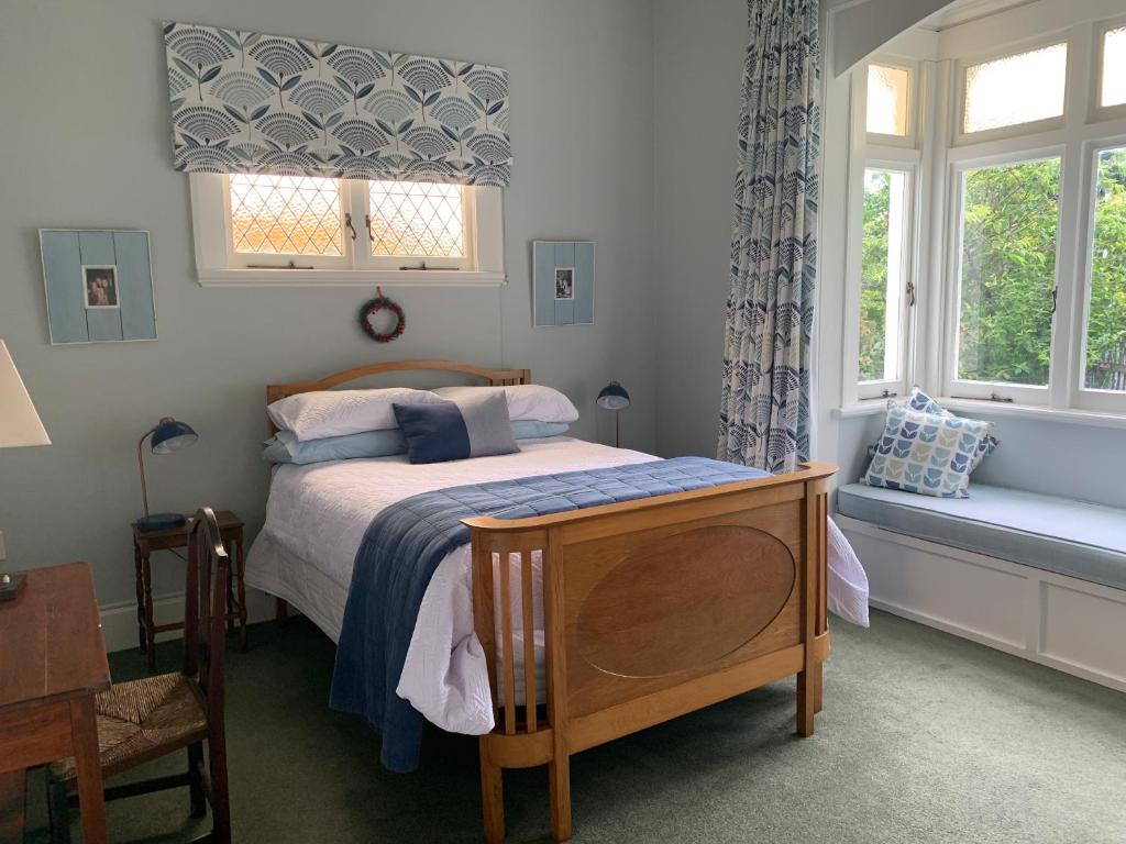 a bedroom with a bed and two windows at Hawkes Bay Villa-Beechwood in Hastings