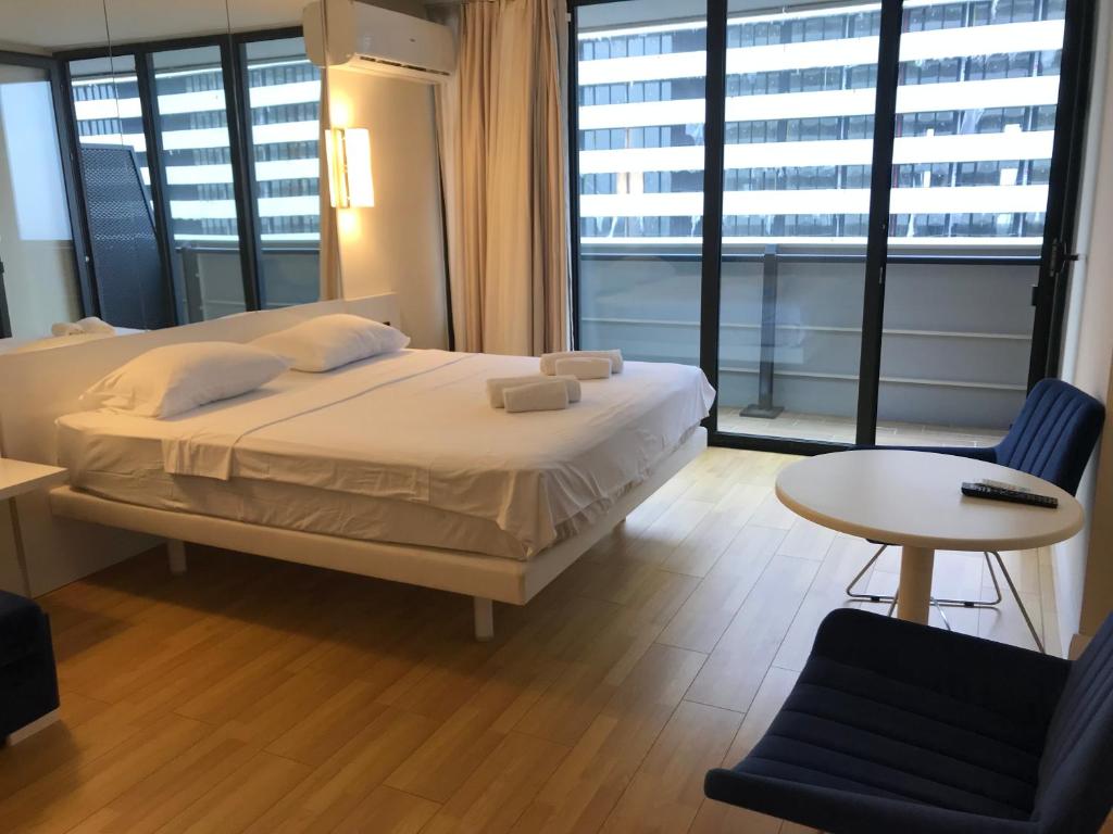 バトゥミにあるBatumi Residence In Orbi Cityのベッドとテーブルと椅子のある寝室