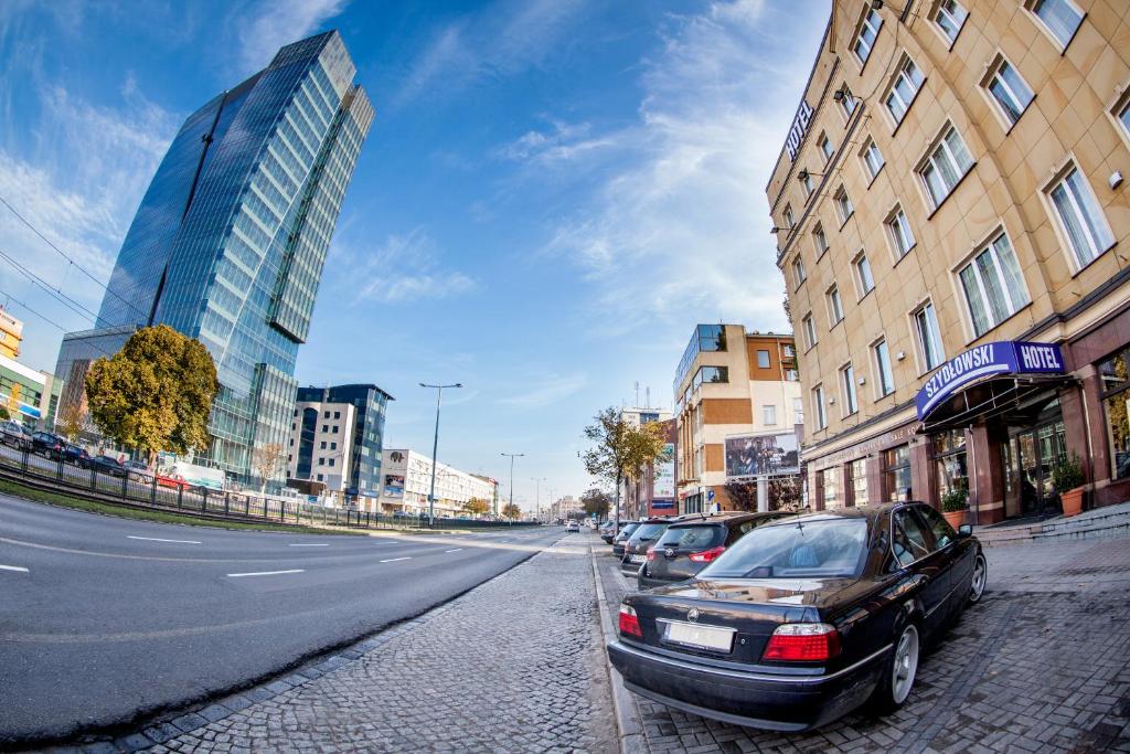 a car parked on the side of a street with buildings at Hotel Szydłowski in Gdańsk