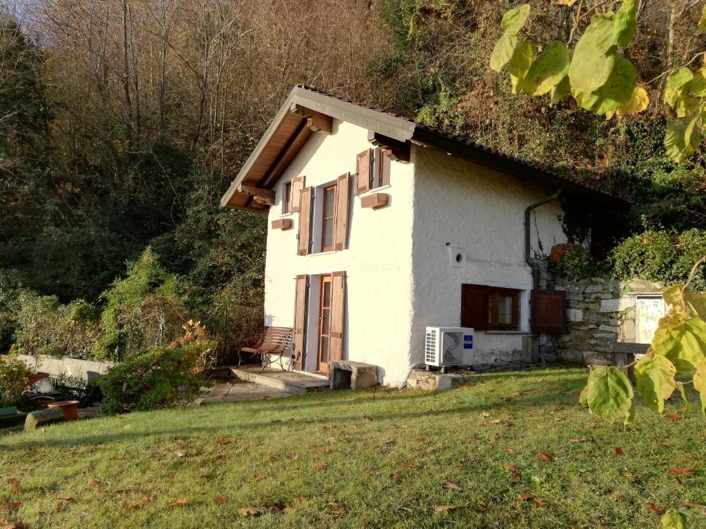 a small white house with an ivy covered roof at Romantica casetta nel verde con vista sul lago in Belgirate