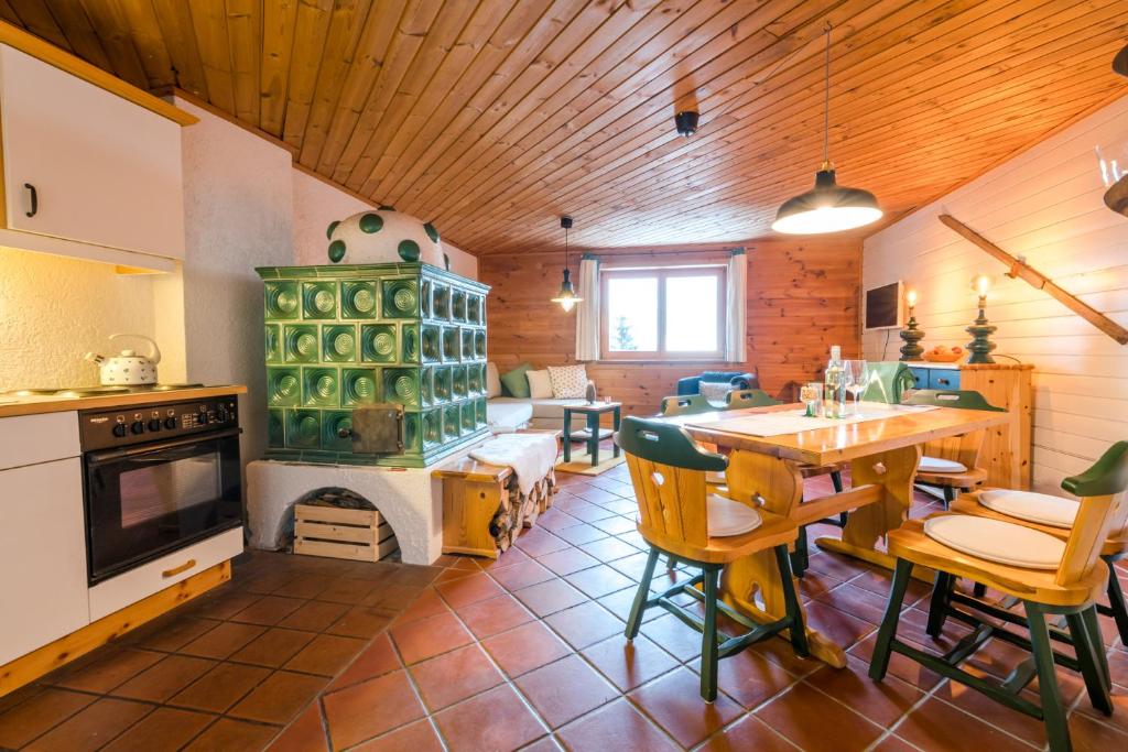 ein Wohnzimmer mit einem Kamin, einem Tisch und Stühlen in der Unterkunft Hütte Gerlitzen RegioJet Hotels&Cottages in Bodensdorf