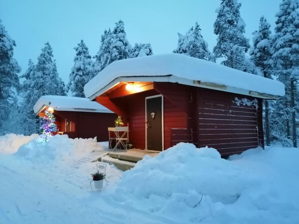 a cabin in the snow at night at Lemmenjoki Camping EcoCabins in Lemmenjoki