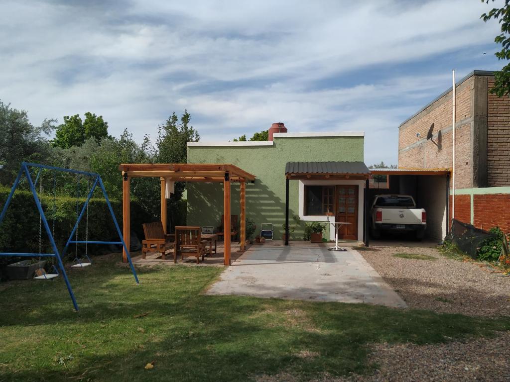 un patio trasero con columpios y un edificio en Departamento Mi Sueño en San Rafael