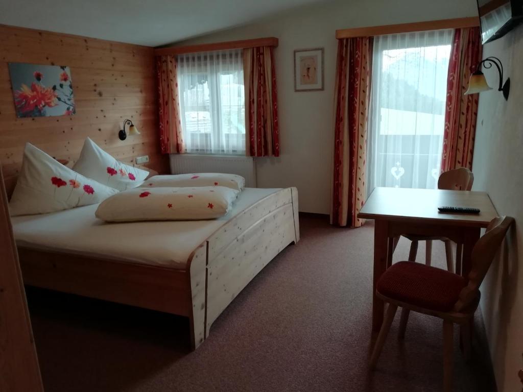 Schlafzimmer mit einem Bett, einem Schreibtisch und einem Tisch in der Unterkunft Ferienwohnung Angererhof in Reith im Alpbachtal